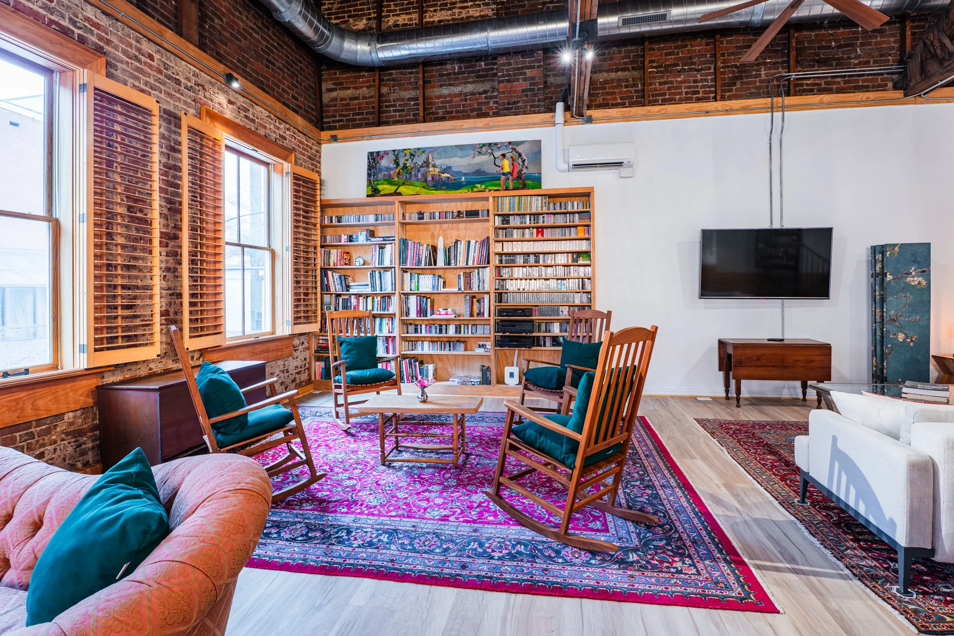 Sitting area with curated bookshelf, board games, and Bluetooth speaker