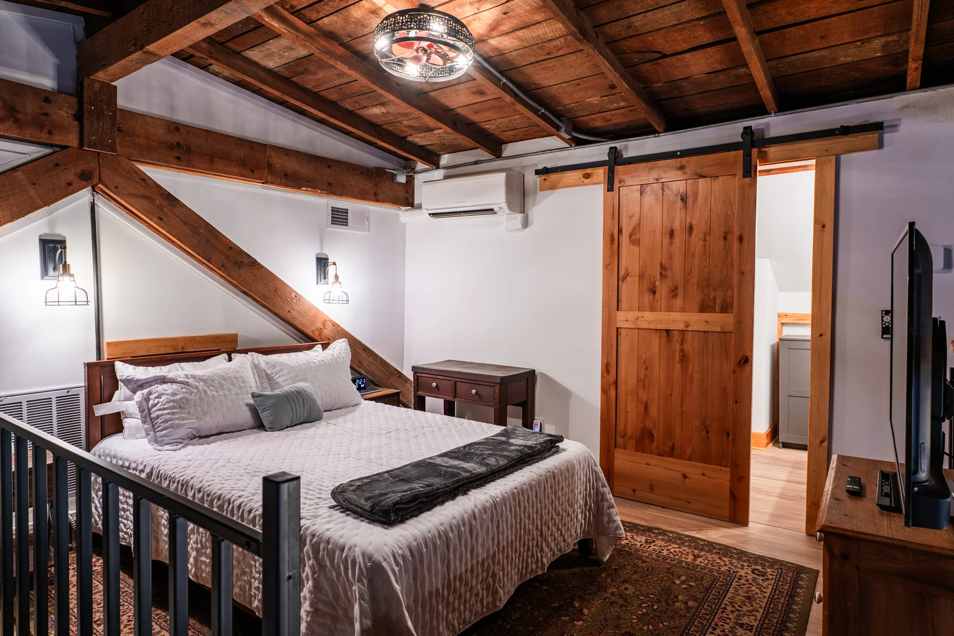 Mezzanine bedroom beneath original wooden rafters and beams